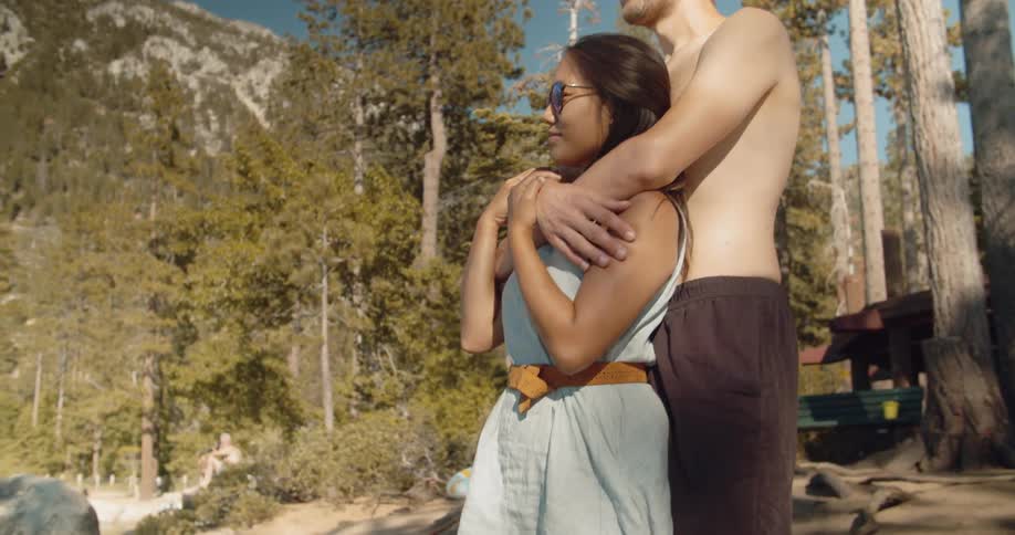 A man hugs a woman by the mountain