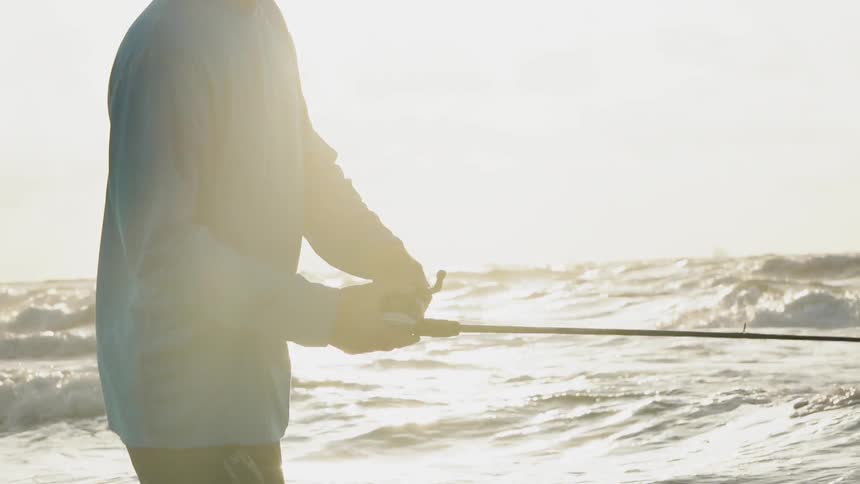 Man fishes in the ocean on a sunny day
