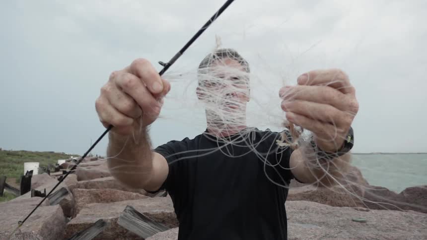 A man holds up tangled fishing line