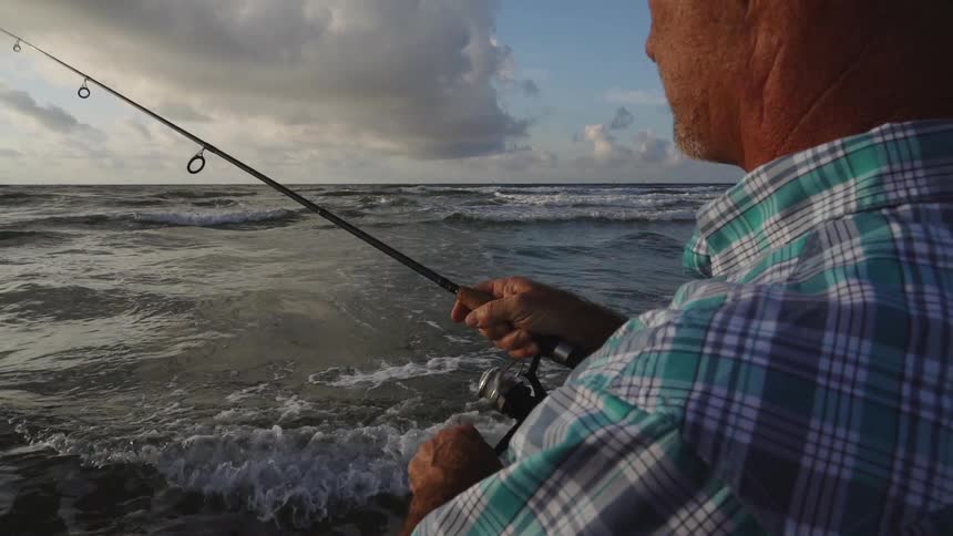 A man is fishing on the beach