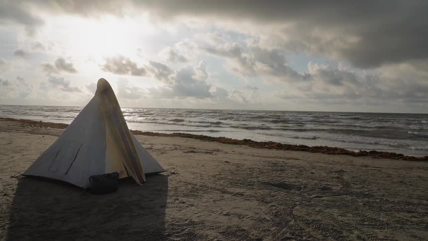 Tent on ocean beach on cloudy day