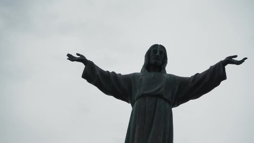 A statue of a man is holding its arms out