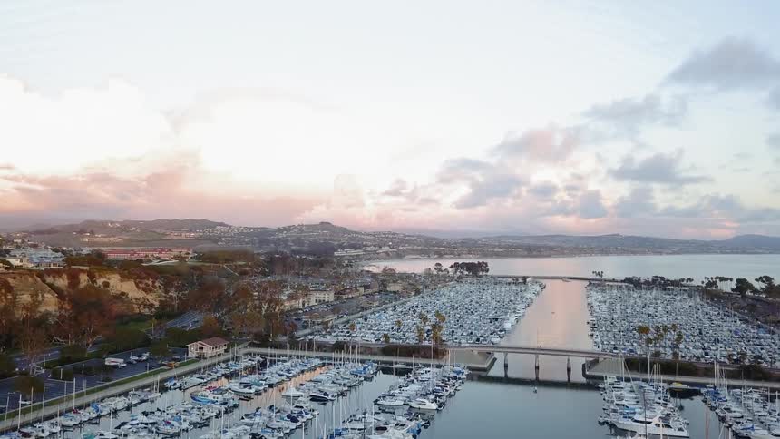 Boats float in a marina at sunrise