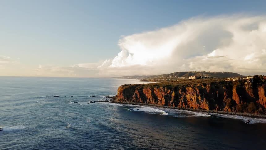 The wave crashes against the cliffs of the shore