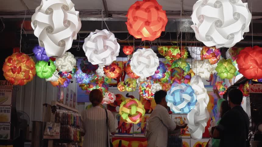 People shop in a store with low hanging paper lanterns
