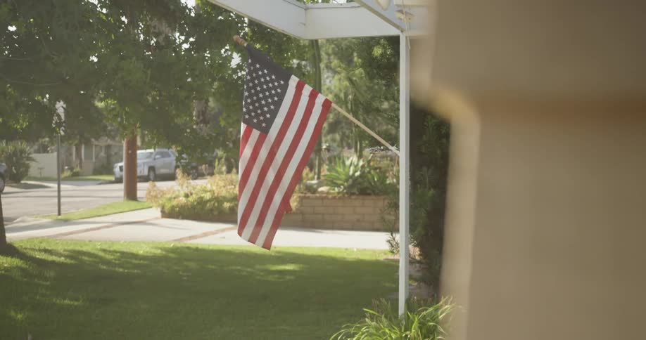 Flag hangs off a house waving in the wind