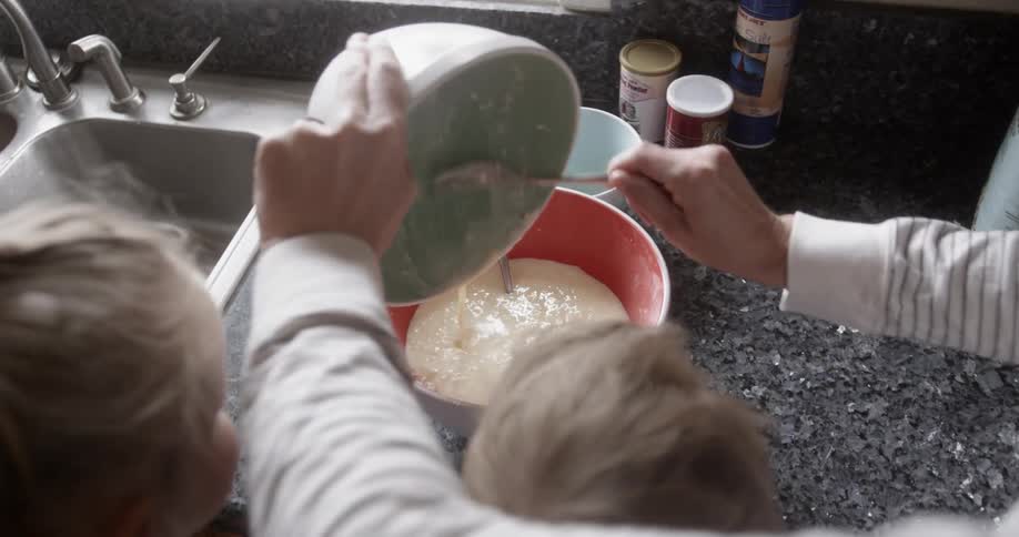 A parent cooks with their children at home