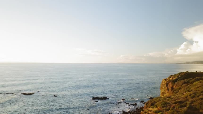 Sunlight shines on ocean waves on a shoreline