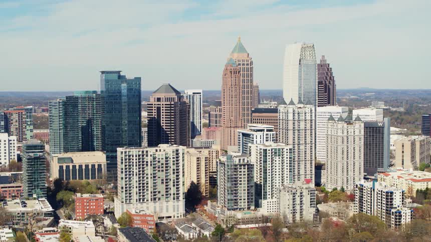Skyscrapers and high rises in a city are standing tall against a cloudy sky