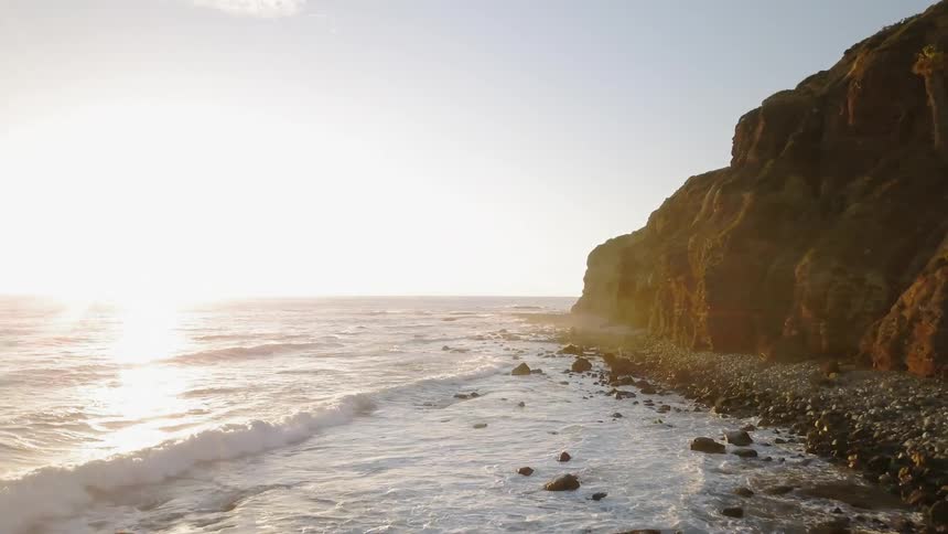 Sunlight shines on ocean waves on a shoreline