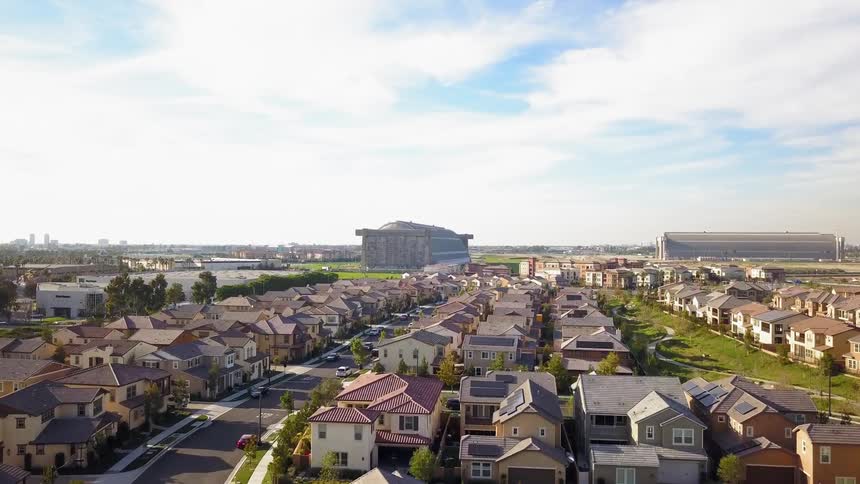 Houses in a suburban neighborhood are lining streets under a cloudy sky