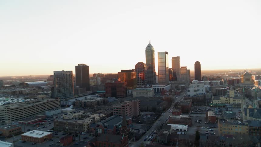 The sun sets behind city skyscrapers
