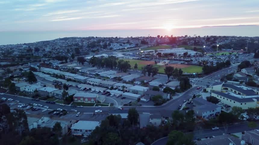 The sun is rising on the horizon beyond a coastal community
