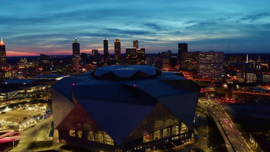 A large building stands in a city at dusk