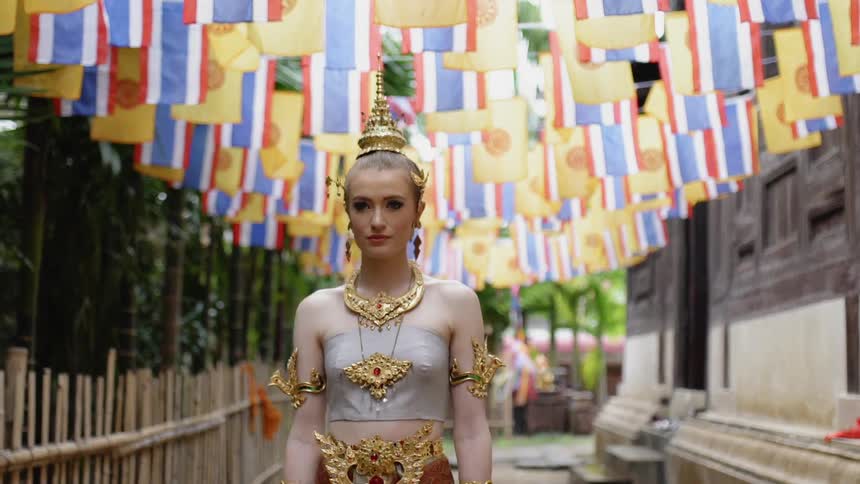 A woman in a dress walks under flags