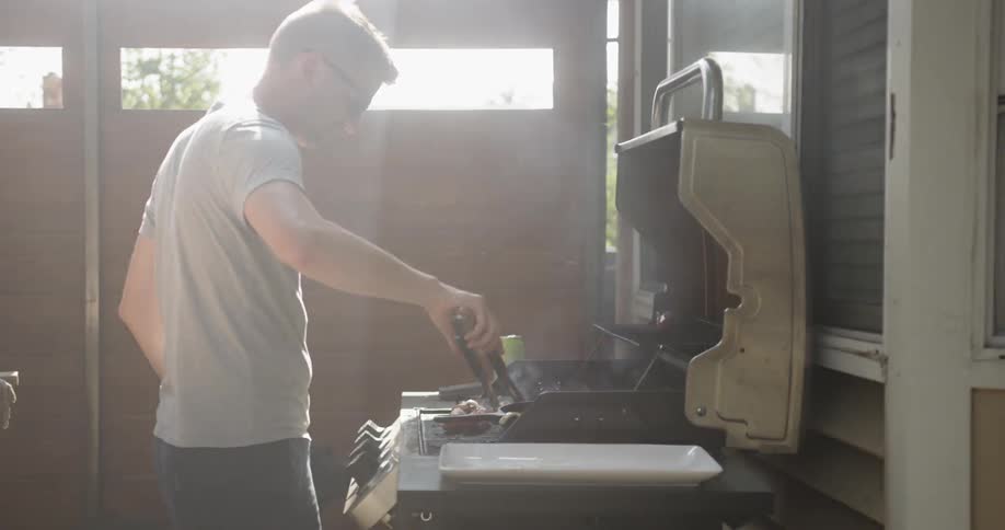 A man is cooking food on the barbecue