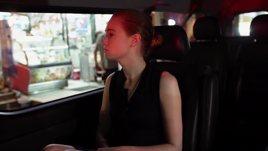 Person sits in a vehicle riding down a city street