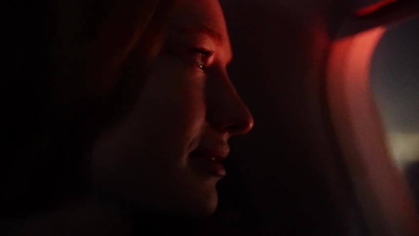 A light shines on a woman's smiling face at night