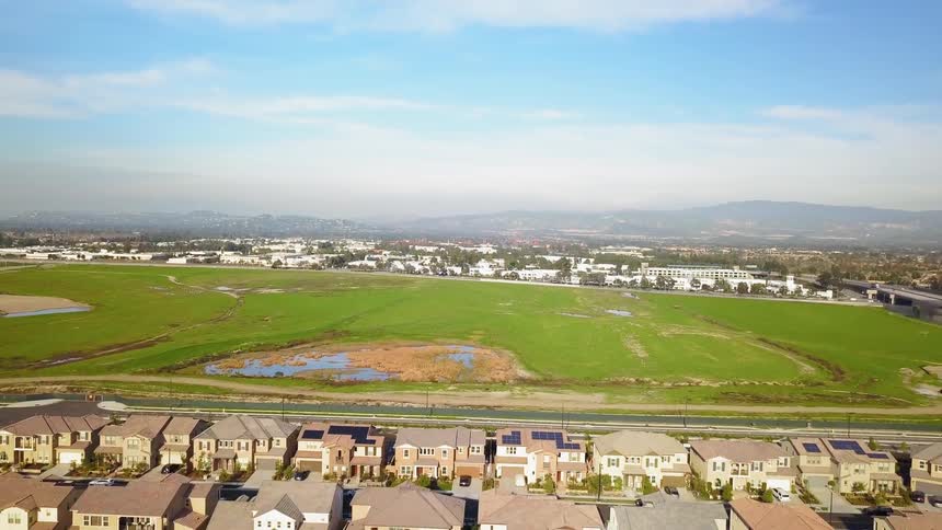 The green field leads to many homes
