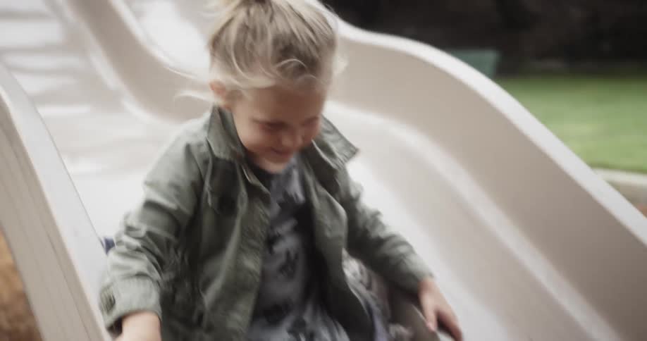 A young girl plays on a park slide