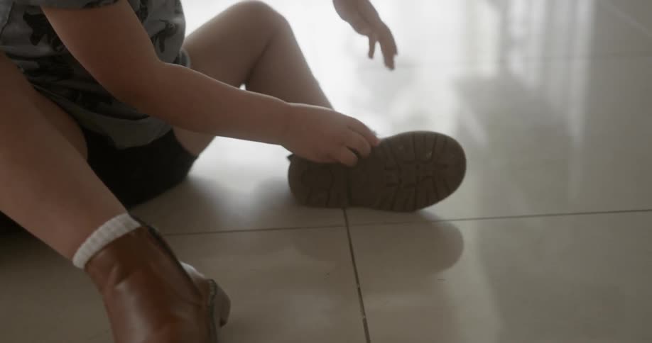 Young child puts on a pair of shoes
