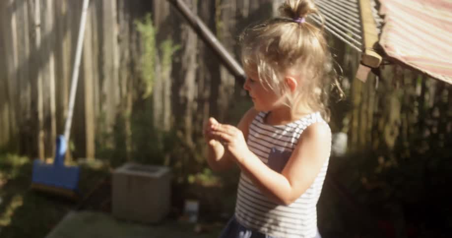 A young girl throws a popper outside