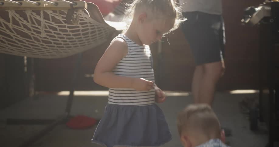 A boy and girl throw snaps against the patio on a sunny day