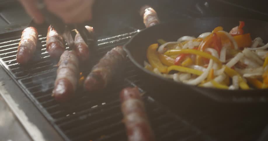 The sausages are being turned on the grill