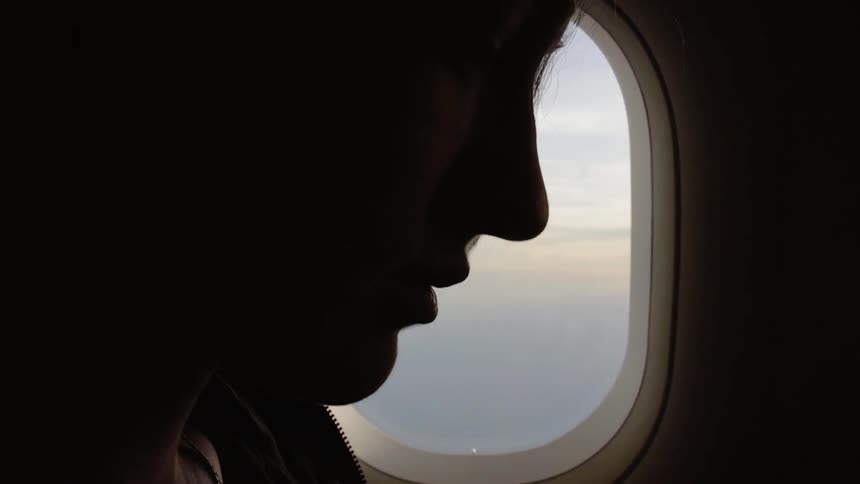 Silhouette of a person sitting in an airplane