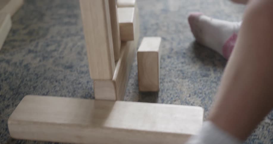 Man and child play with large wooden blocks