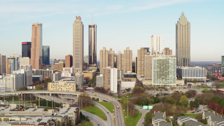 Cars traveling on freeway in between tall buildings in city