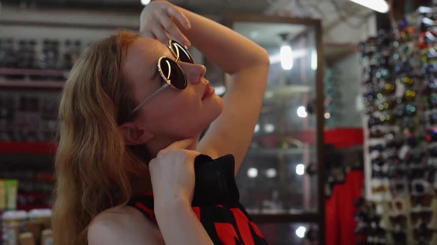 A woman tries on sunglasses