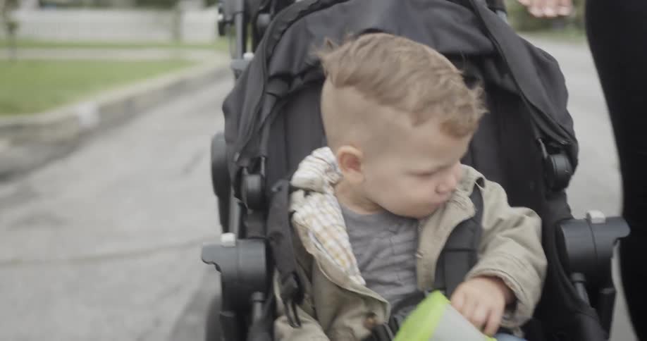 People walking a child in a stroller down the street