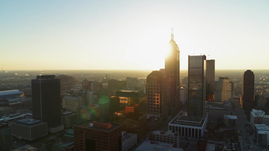 The sun is setting behind the buildings