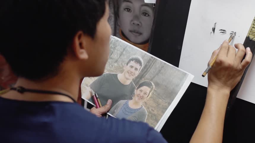 Person looks at a picture and paints it