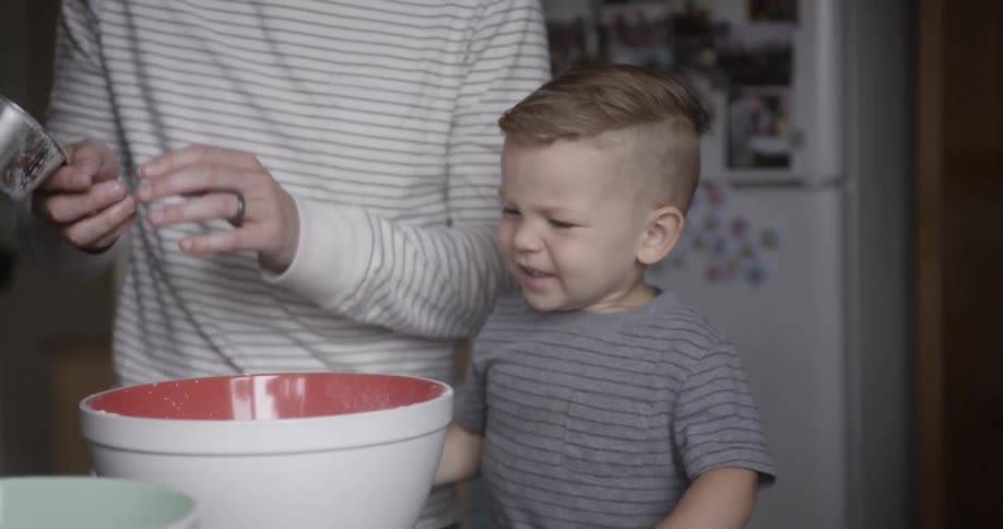 Man helps toddler pour flour into bowl