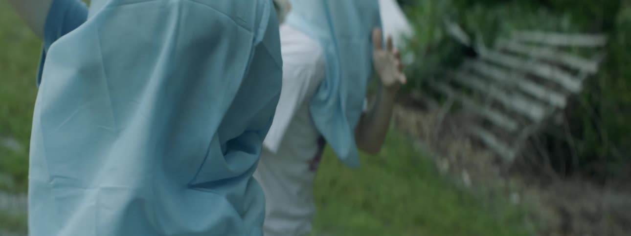 People dance outside with bags covering their faces
