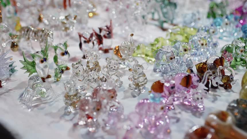 Glass trinkets sit on a table in a store