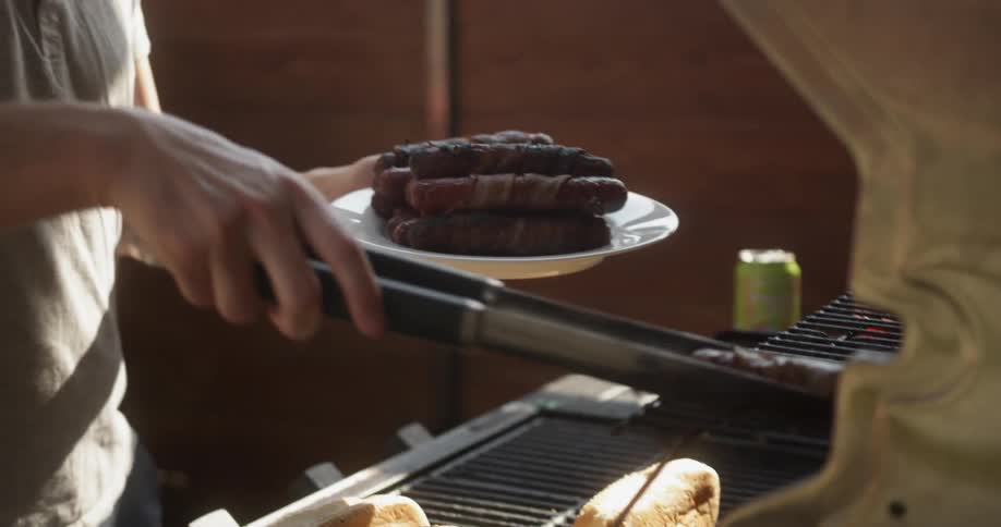 A person removes some meat from the barbecue