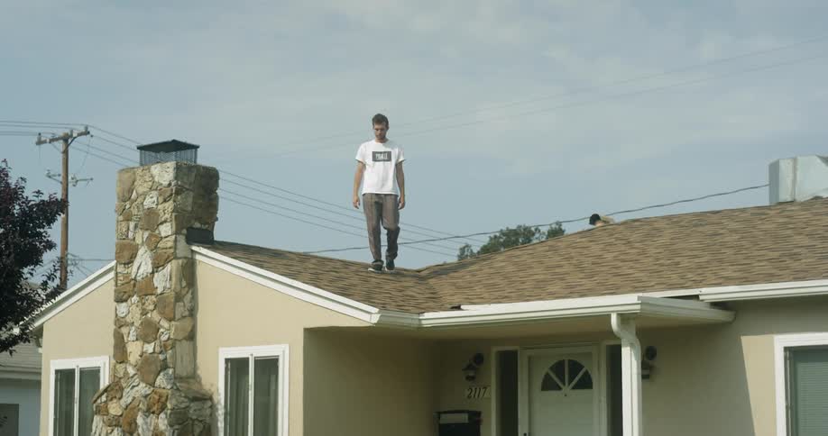 Man walks on a shingled roof
