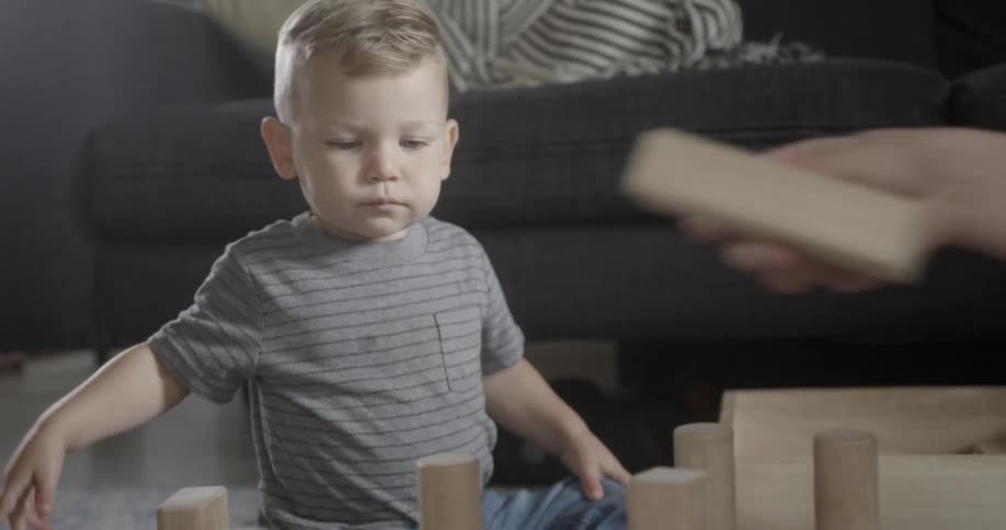 A young boy plays with toys at home