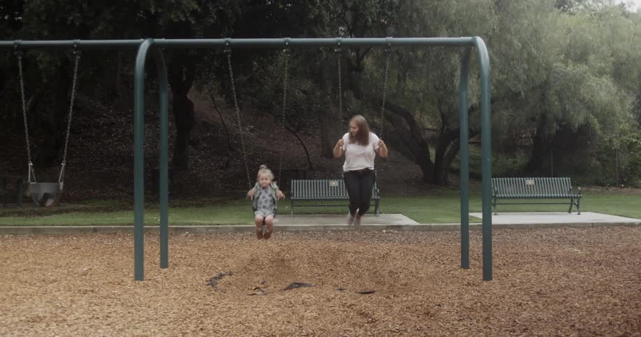 A mother and child swing in the park