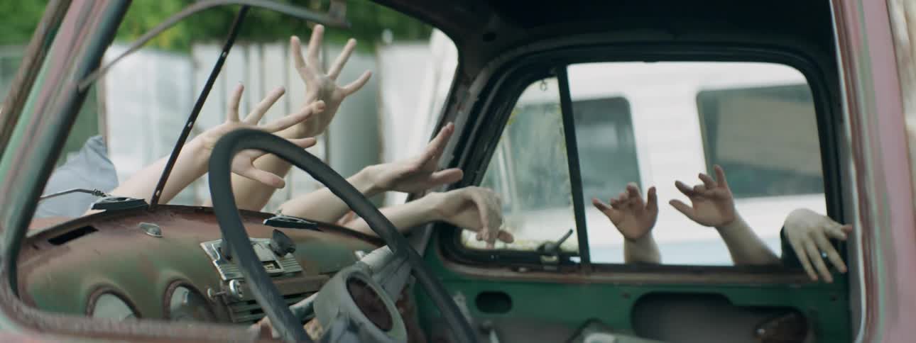Hands reach into an abandoned car