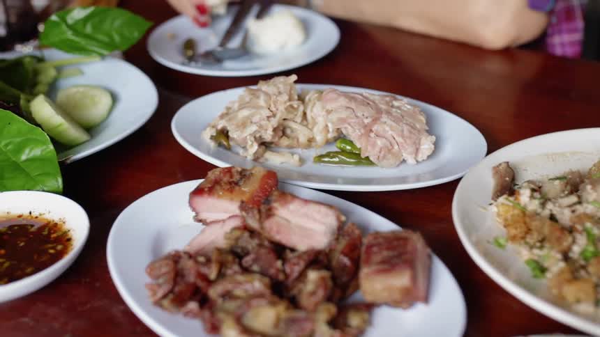 Several courses of a meal are sitting on a dinner table in daylight