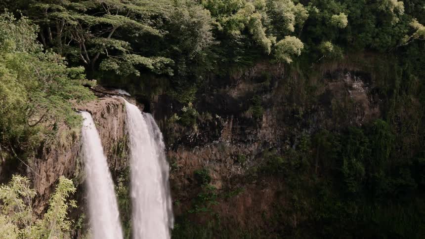 Waterfalls flow over a cliff in the wilderness