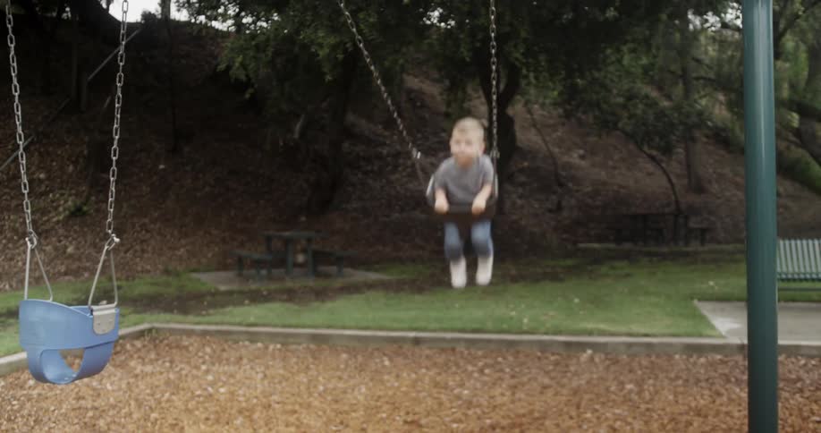 Baby is being pushed on a swing