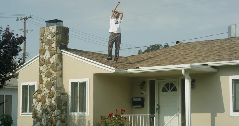 Man stands on the roof of a house