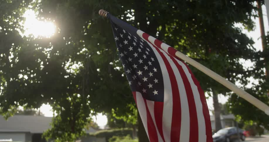 American flag is swaying in the breeze in neighborhood