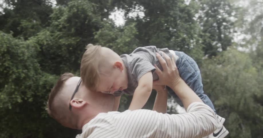 A father lifts his son above his head