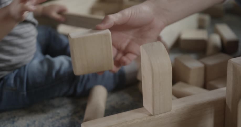 Adult and baby are stacking toy blocks